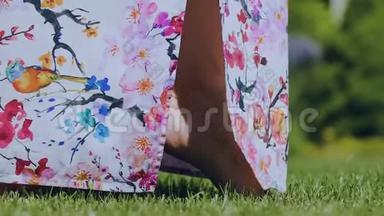 女人脚趾头穿着五颜六色的衣服走在绿草上，春天来到了户外